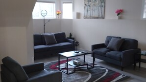 A modern living room with two sofas, a coffee table, and a rug. - Luxurious 2 BDRMS Basement Legal Suite (Edmonton)