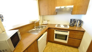 A compact kitchen with a microwave, sink, dishwasher, stove, and coffee maker. - Apartment in Duinbergen Near Sandy Beach (Knokke-Heist)