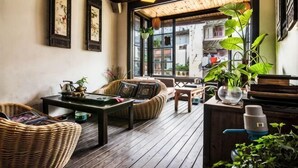 A cozy room with wicker furniture, a wooden ceiling, and large windows. - Shanghai Jiaoli Xiaoyan Inn (Zhujiajiao Scenic Area Ancient Town) (Shanghai)