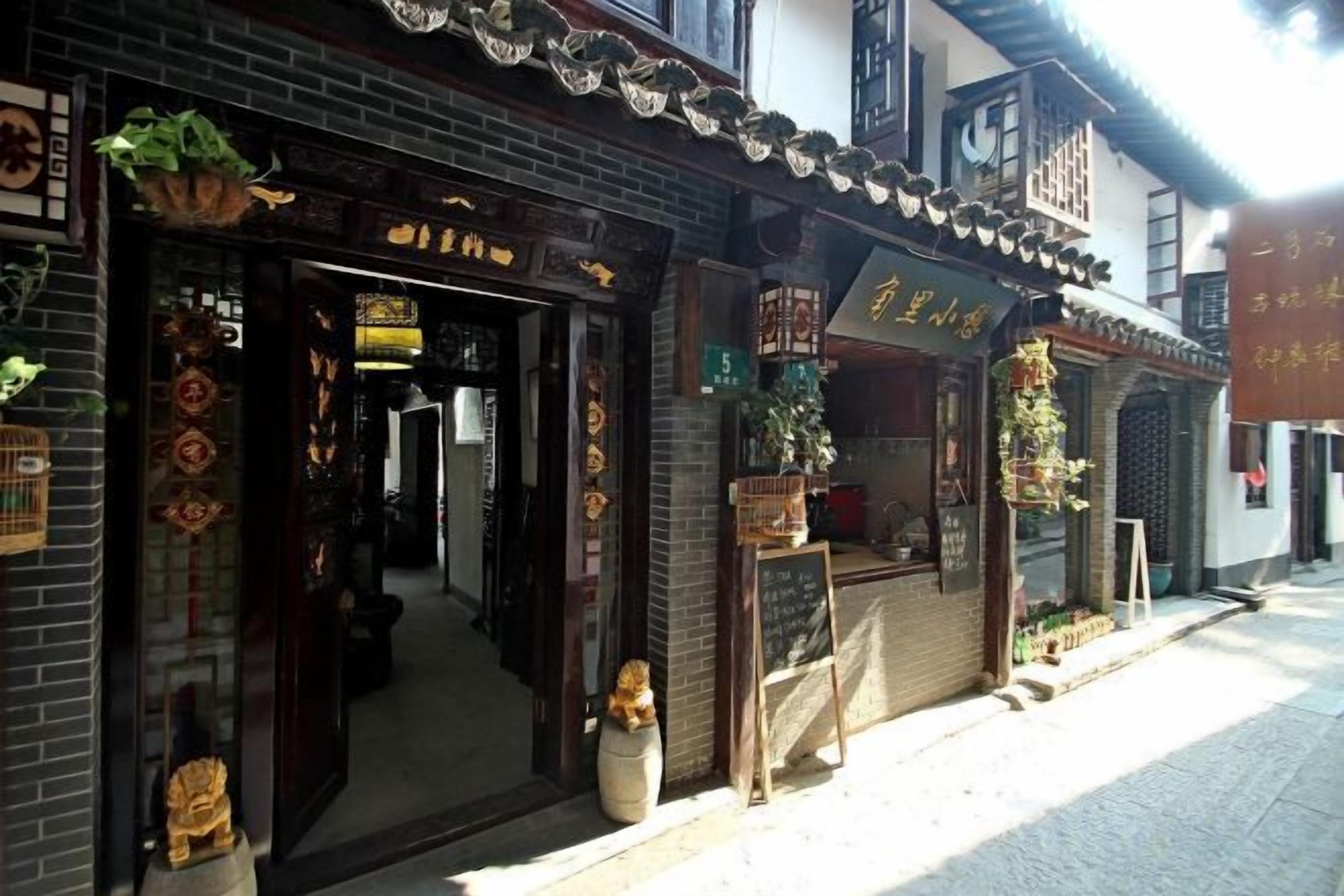 Een traditioneel Chinees gebouw met een winkelgevel, decoratieve details en een bord.