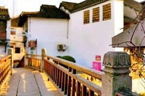 Um edifício tradicional com grade de madeira e coluna de pedra, sugerindo um local histórico ou cultural.