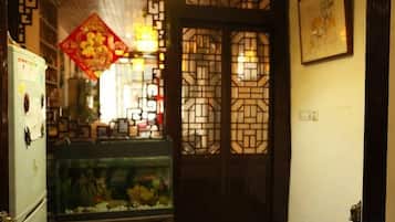 A traditional interior with a decorative door, a fish tank, and a refrigerator.