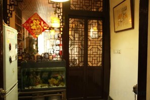 A traditional interior with a decorative door, a fish tank, and a refrigerator.