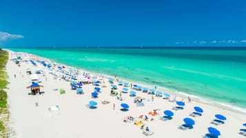 On the beach, white sand, sun loungers, beach umbrellas