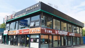 A commercial building with multiple storefronts, including a visible sign for Bingcheng C&B.