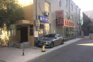 Een gebouw met een winkelgevel en een geparkeerde auto.