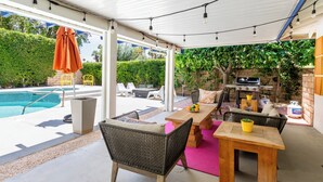 An outdoor patio with a pool, seating area, and barbecue setup. - Mid-Century Modern | Pool & Spa | Mountain Views (Palm Springs)