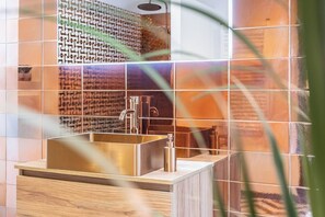Ein modernes Badezimmer mit einem rechteckigen Waschbecken, einem Spiegel und einer Duschkabine.
