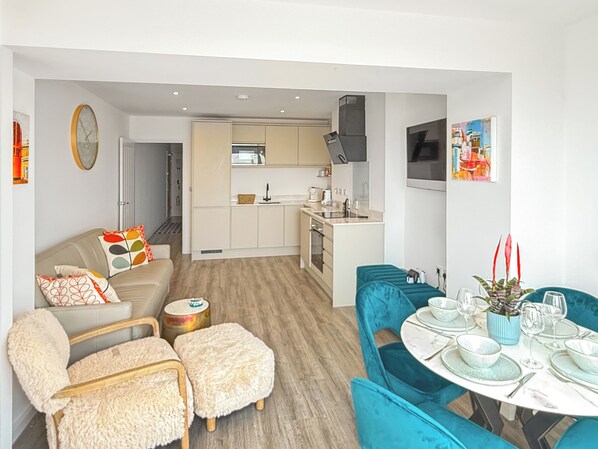 A modern apartment with a living room, kitchen, and dining area.