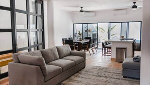 Ein großzügiger Wohnbereich mit Sofa, Esstisch, Stühlen und Kücheninsel.