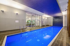 Swimmers can enjoy the pool surrounded by a tiled floor and walls.