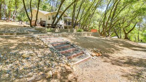 A house with a porch and steps leading up to it, surrounded by trees. - Yosemite Home Base: Community Perks + Lake Access! (Groveland)