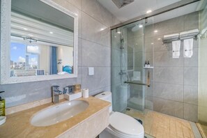 A modern bathroom with a glass-enclosed shower, a marble sink, and a toilet. - Mengzi Fengjing Boutique Hotel (Mengzi)