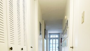 A hallway with white lockers on one side and a door at the end.