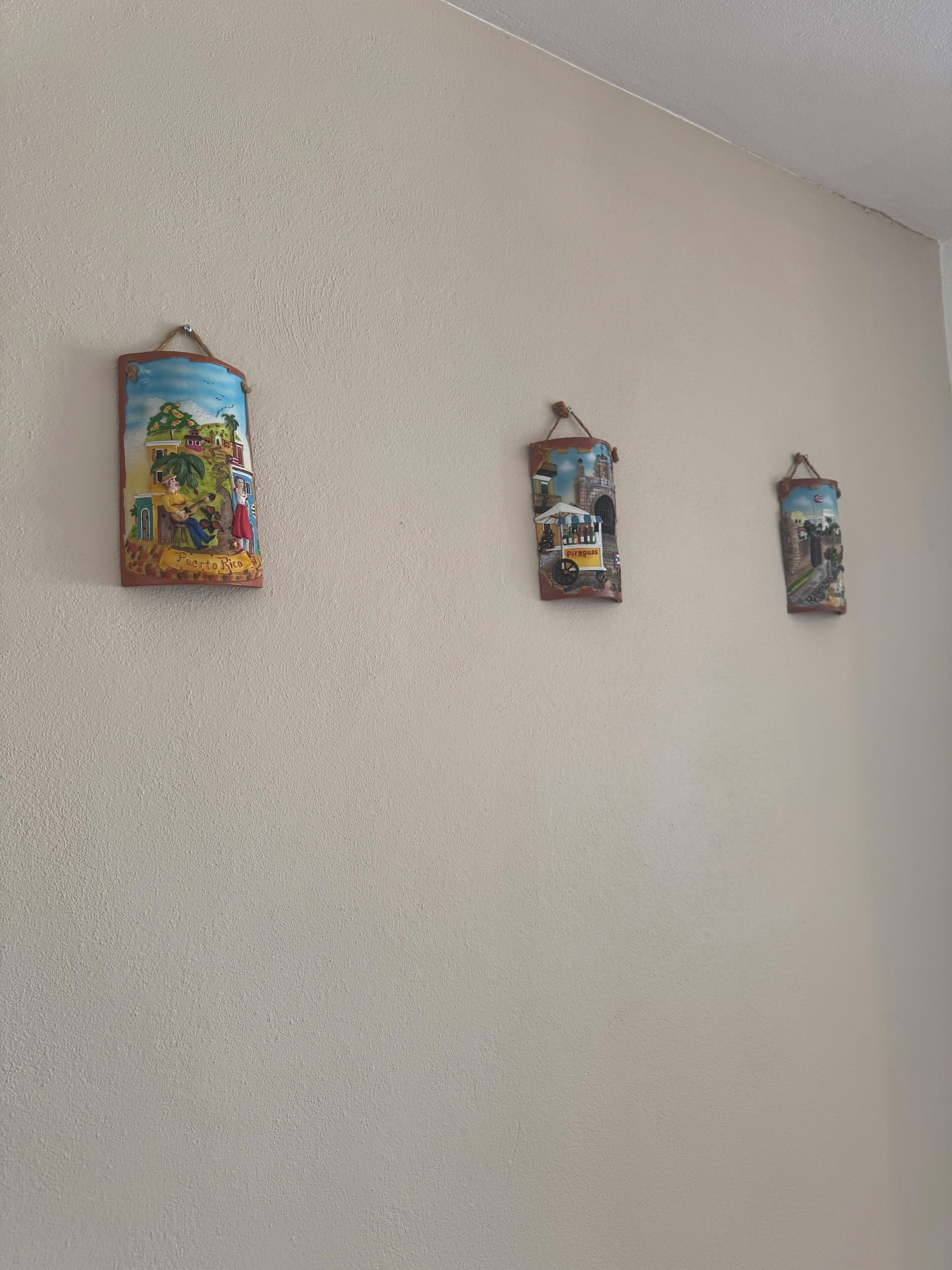 Trois éléments de décoration à accrocher au mur, représentant des scènes de Porto Rico.