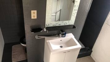 Een haardroger, handdoeken, zeep, toiletpapier