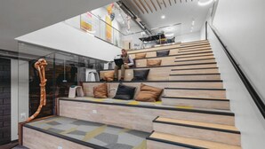 A modern staircase with wooden steps and black edges, leading to a second floor. - Cedar Tree House 319 (Traverse City)