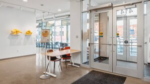A modern hotel lobby with a reception desk, seating area, and large glass doors leading outside. - Cedar Tree House 319 (Traverse City)