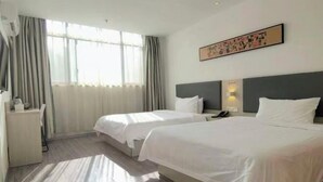 A hotel room with two beds, a desk, a chair, a window with curtains, and a wall-mounted artwork. - Kaimanguoji Hotel (Shanghai Dongjing Branch) (Shanghai)