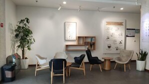 A modern waiting area with several chairs, a small table, and a plant. - Kaimanguoji Hotel (Shanghai Dongjing Branch) (Shanghai)