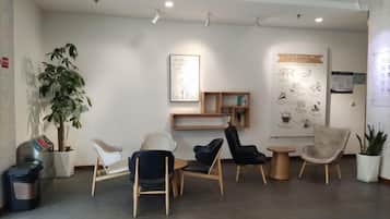 A reception area with seating, a plant, and informational posters.