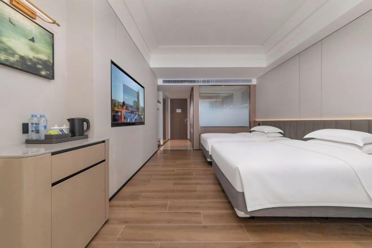 Une chambre d’hôtel avec un lit, un bureau doté d’une bouilloire et une fenêtre.