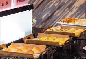 Un bufé con diversos alimentos dispuestos en tablas de madera.