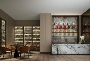 A modern hotel lobby with a marble reception desk, a seating area with chairs, and shelves displaying various items.