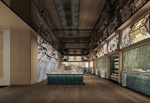 Un hall d’hôtel spacieux, doté d’un îlot central, de grandes fenêtres et d’un plafond haut.