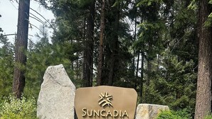 A sign with the name 'SUNCADIA' surrounded by greenery and trees. - Luxury Lodge Retreat in the Heart of Suncadia – Walk to Golf, Winery & Trails (Cle Elum)