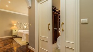 Un dormitorio con cama, mesita de noche y armario con espejo.