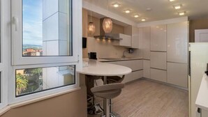Una cocina moderna con un ventanal grande, luces colgantes y vistas a la ciudad.