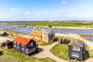 A coastal village with houses near the water, a dock, and a bridge. - Ocean View, Walberswick (Walberswick)