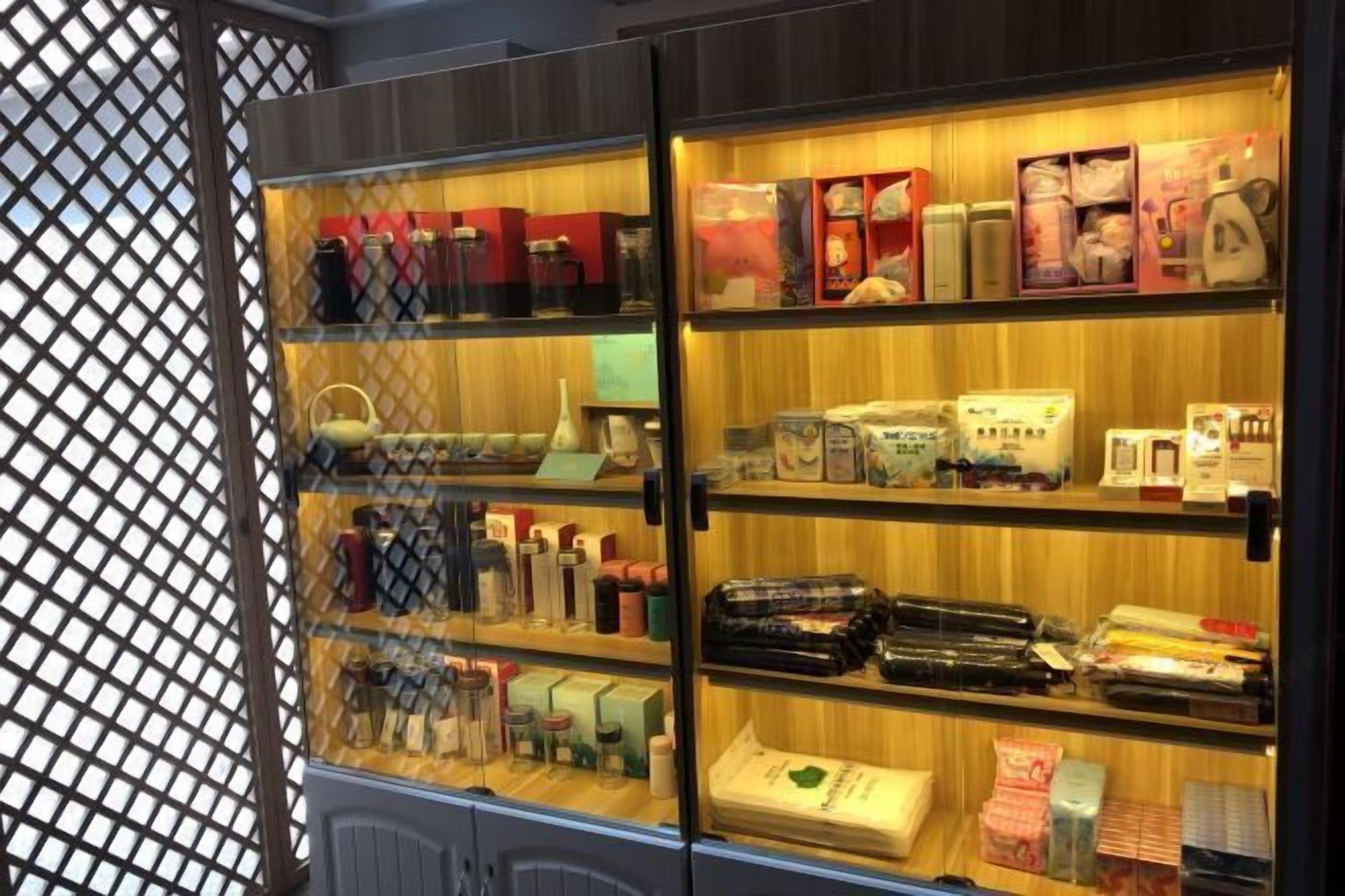 Eine gläserne Vitrine mit verschiedenen verpackten Waren, darunter Flaschen und Kartons, vermutlich in einem Einzelhandels- oder Hotelbereich.