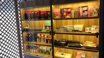 Eine gläserne Vitrine mit verschiedenen verpackten Waren, darunter Flaschen und Kartons, vermutlich in einem Einzelhandels- oder Hotelbereich.