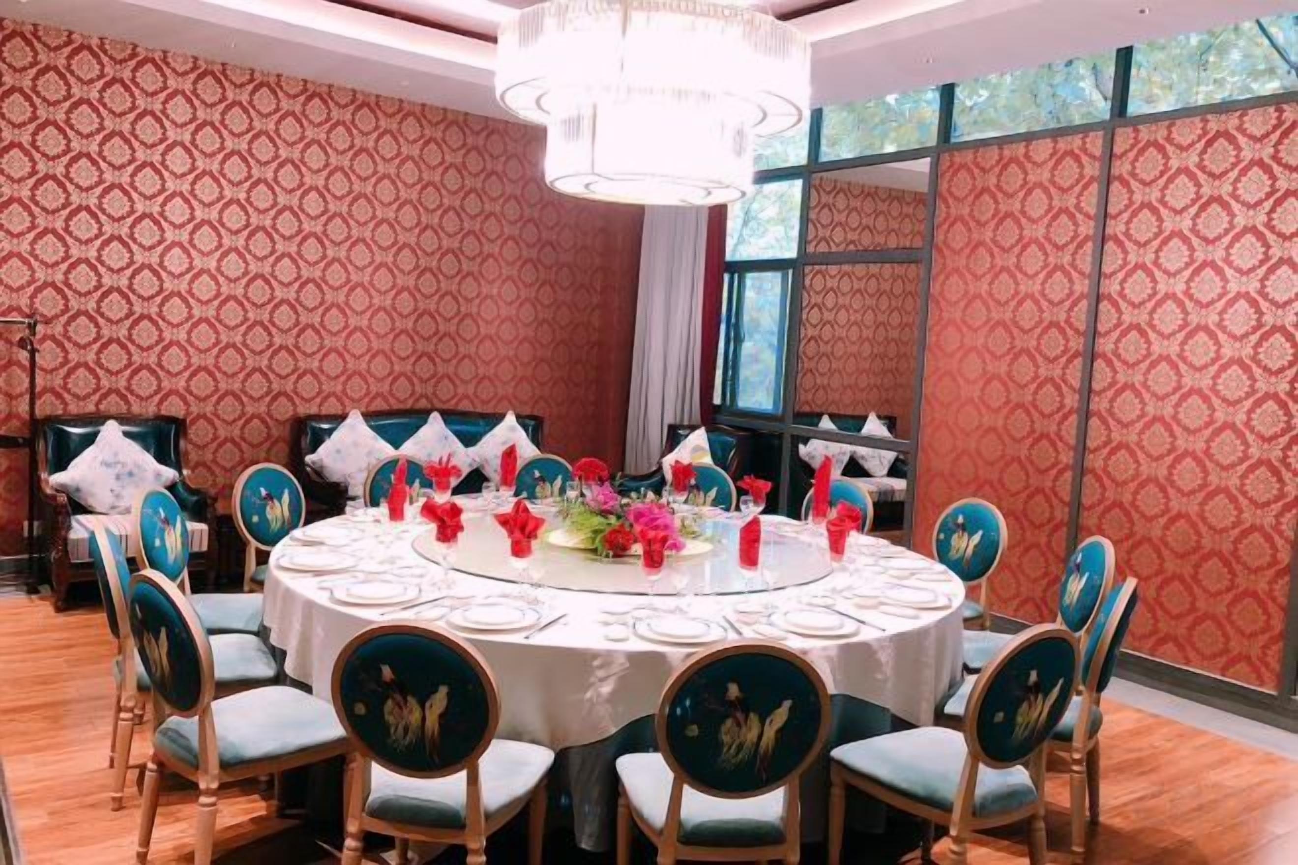 A conference room with a round table, chairs, and a chandelier.