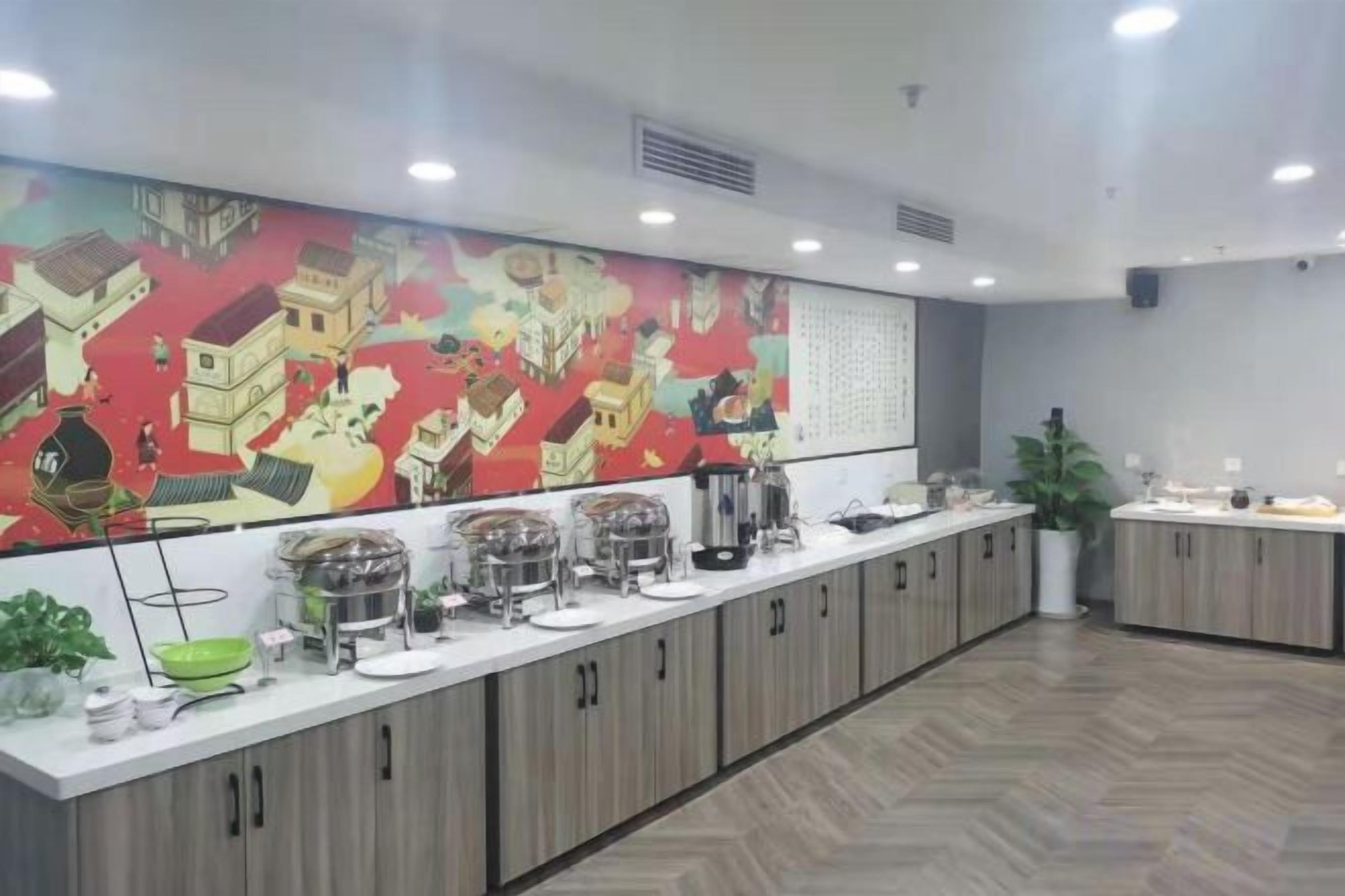 A long counter with various food containers and a large colorful mural on the wall.