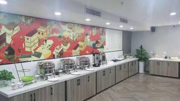 A long counter with various food containers and a large colorful mural on the wall.