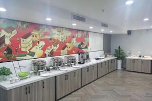 A long counter with various food containers and a large colorful mural on the wall. - Grand Cozy Hotel (Nanjing University of the Arts Longjiang Subway Station Store) (Nanjing)