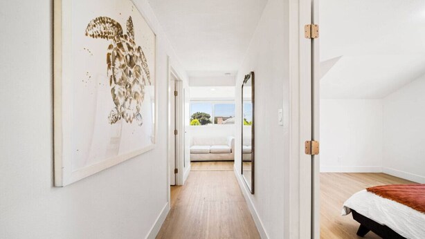 A hallway leading to a bedroom with a bed, a large mirror, and a framed artwork on the wall. - 2Bedroom home - Marengo Estate (Alhambra)