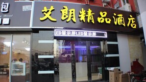 Une devanture de magasin avec une enseigne aux lettres jaunes, une porte vitrée et quelques cartons à l’extérieur.