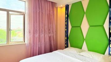 A bedroom with a bed, a window, and a wall with a geometric design.