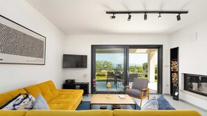 Ein modernes Wohnzimmer mit einem gelben Sofa, einem Flachbildfernseher und einem Kamin.