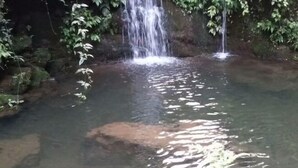 A clear, shallow water body with a small waterfall, surrounded by rocks and greenery. - Xiushan Hotel (Emeishan City)
