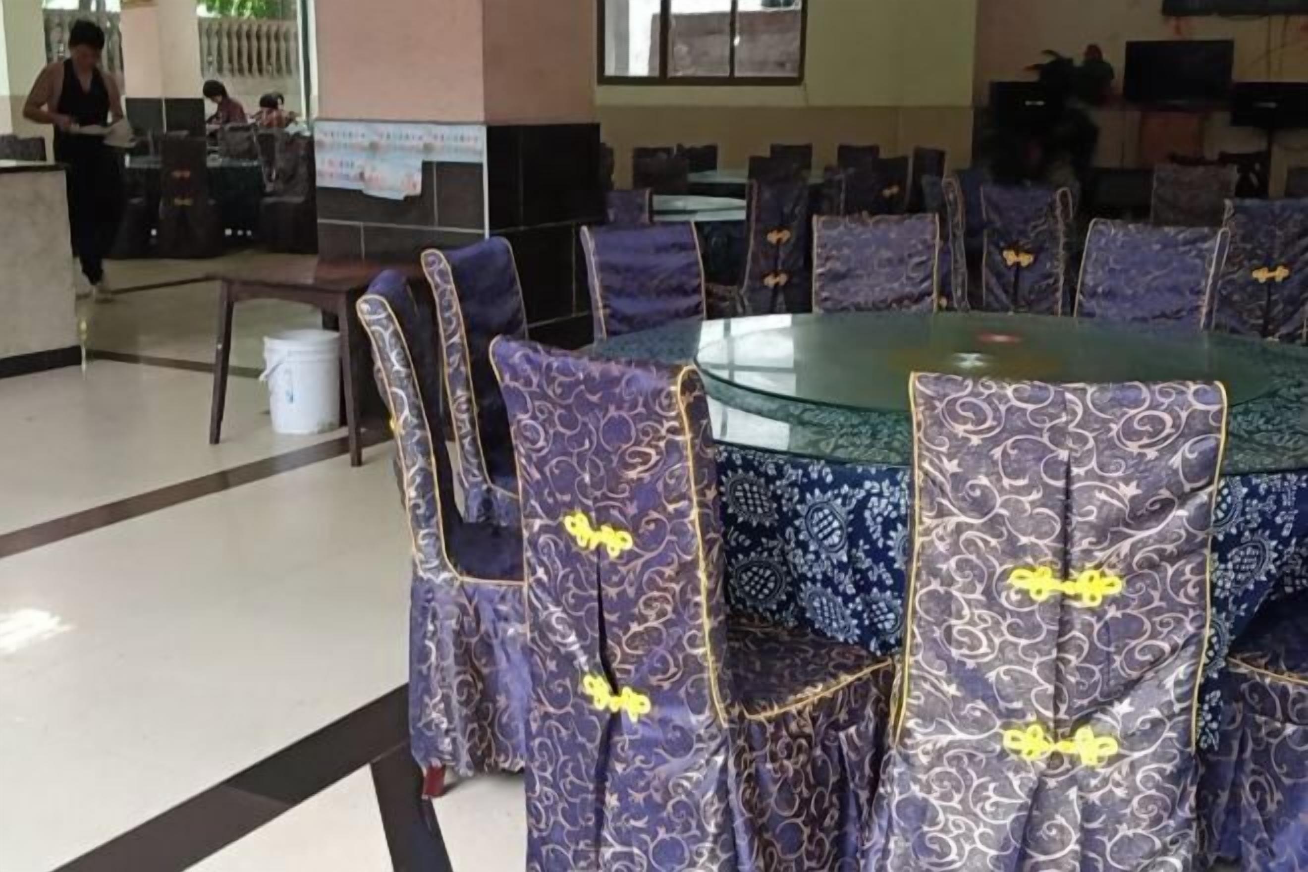 A dining area with round tables and chairs with patterned upholstery.