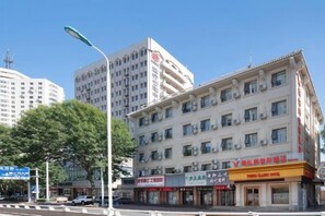 Ein mehrstöckiges Gebäude mit Geschäften im Erdgeschoss, darunter ein Restaurant und ein Hotel.