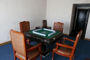 Een kamer met een pooltafel, vier houten stoelen en een deur op de achtergrond.