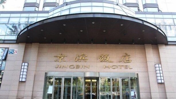 A hotel entrance with a curved roof and large glass doors. - Jingbin Hotel (Beijing)