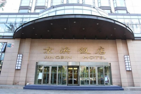 A hotel entrance with a curved roof and large glass doors.
