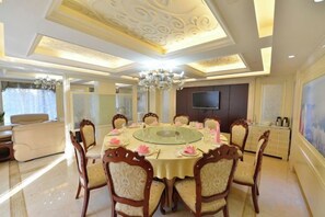 A dining area with a round table, chairs, and a chandelier. - Jingbin Hotel (Beijing)